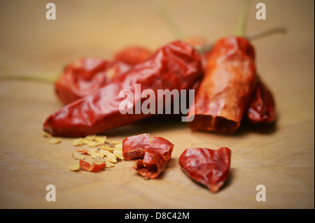 In Scheiben geschnitten, getrocknet, Serrano (Sport) Chili-Schoten und Samen auf ein Schneidebrett. Capsaicin, Analgetikum, leitet sich aus Chilischoten. Stockfoto