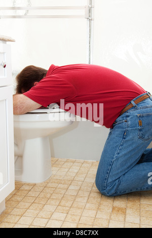 Mann im Badezimmer, Erbrechen in die Toilette. Stockfoto