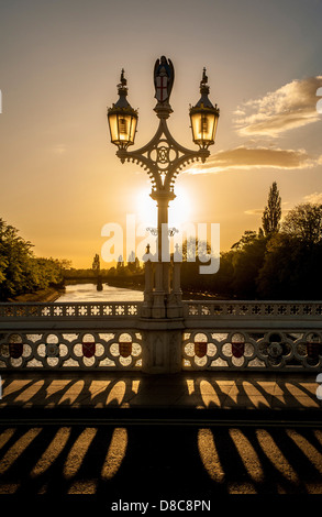 Hintergrundbeleuchtete Straßenlampen und Geländer auf der Lendal Bridge mit der Scarborough Railway Brücke und dem Fluss Ouse im Hintergrund. York, Großbritannien Stockfoto