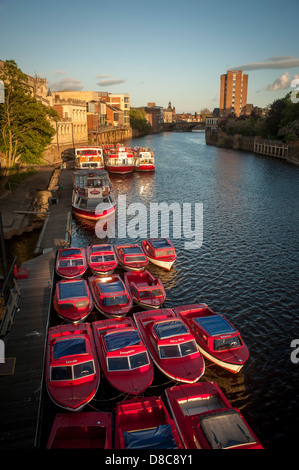 River Ouse mit einer Flotte von Kreuzfahrt- und Touristenausleihbooten, die an einem sonnigen Sommerabend in York an der Guildhall festgemacht wurden. Stockfoto