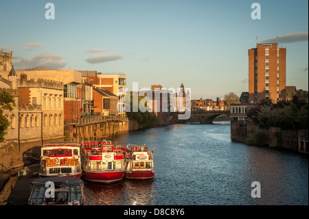 River Ouse an einem sonnigen Sommerabend mit festfahrenden Kreuzfahrtbooten und der Ouse Bridge in der Ferne, York, Großbritannien. Stockfoto