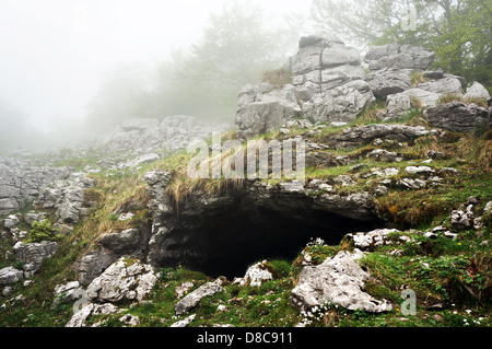 Eingang der Grotte in den Bergen mit Nebel Stockfoto