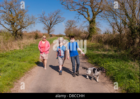 Eine Frau und ihre beiden Söhne, Spaziergang mit dem Hund auf einem Feldweg in Sotterley, Suffolk, England, Großbritannien, Großbritannien Stockfoto