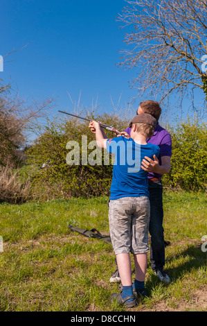 Ein 9-jähriger Junge,.410 Schrotflinte im Vereinigten Königreich zu schießen lernen Stockfoto