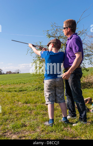 Ein 9-jähriger Junge,.410 Schrotflinte im Vereinigten Königreich zu schießen lernen Stockfoto