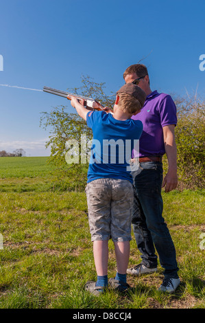 Ein 9-jähriger Junge lernen, eine Schrotflinte 12 Bohrung im Vereinigten Königreich zu schießen Stockfoto