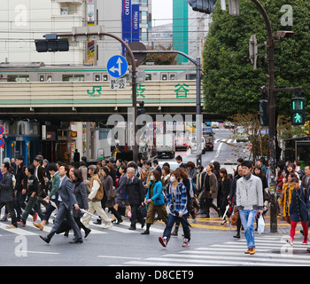 Menschen, die über die Straße an der berühmten Shibuya-Kreuzung in Tokio, Japan Stockfoto