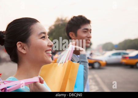 Junges Paar auf der Straße mit Einkaufstüten in Peking, Nahaufnahme Stockfoto