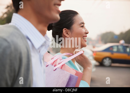 Junges Paar auf der Straße mit Einkaufstüten in Peking, Nahaufnahme Stockfoto