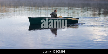 Rudern auf einem ruhigen See wilde Mann Stockfoto