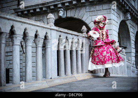 Eine Frau auf der Brücke der Sehenswürdigkeiten mit einem Karnevalsmaske und Kostüm posiert, während der venezianischen Karneval, Italien. Stockfoto