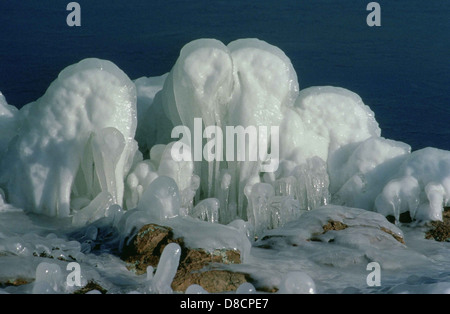 Eisformationen im Winter nehmen komplizierte Formen an und ähneln natürlichen Skulpturen. Diese frostigen Designs sind in gefrorenen Seen, Teichen oder als Eiszapfen zu sehen, die an Strukturen hängen. Stockfoto