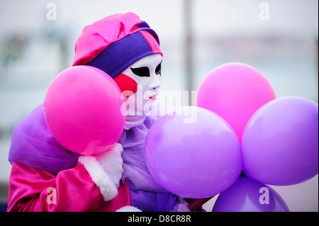 Ein Karneval-Teilnehmer posiert mit Ballons während der Karneval von Venedig, Italien. Stockfoto