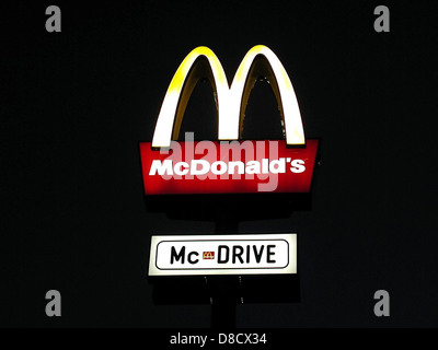 Das legendäre McDonald's-Schild mit seinen goldenen Bögen vor einem klaren Himmel. Das Schild ist ein bekanntes Symbol der globalen Fast-Food-Kette und dient als visuelle Markierung für Gäste, die das Restaurant suchen. Stockfoto