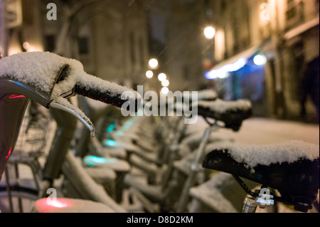 schneebedeckte Fahrräder in Paris Velib-Station. Stockfoto