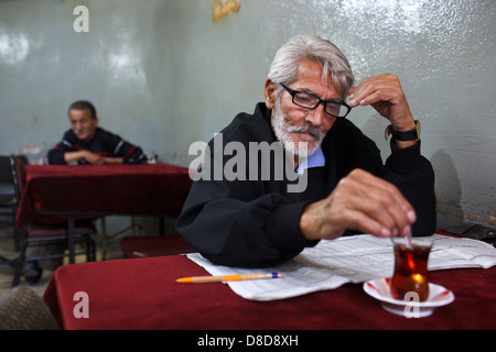 Ein alter türkischer Mann Teetrinken und lesen Zeitung in einem Café (Tee-Shop, Sozialverein) in Balat, Istanbul, Türkei Stockfoto