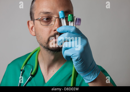 Porträt eines jungen Arztes mit grünen einheitliche Betrachtung Reagenzgläser Stockfoto
