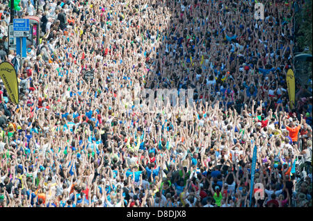 MANCHESTER, VEREINIGTES KÖNIGREICH. 26. Mai 2013. Läufer nehmen an einer organisierten Warm vor Beginn der 2013 Bupa Great Manchester Run auf Portland Street in Manchester. 10km Straße Veranstaltung seit einer jährlichen Fixpunkt im Kalender der Stadt traf es zuerst die Straßen im Jahr 2003. Rund 40.000 Läufer teilnehmen, damit eine der größte Massebeteiligung des Vereinigten Königreichs Laufveranstaltungen. Bildnachweis: News Schüsse Nord/Alamy Live News (nur zur redaktionellen Verwendung). Stockfoto