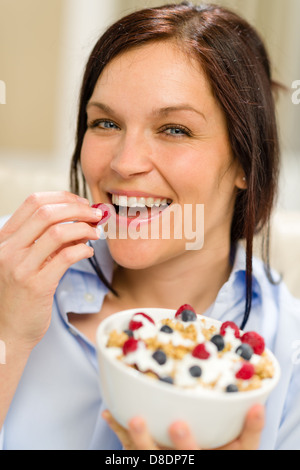 Fröhliche Frau essen gesundes Müsli am Morgen zum Frühstück Stockfoto