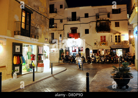 Ein Scooter-Laufwerk vergrößert durch die Straßen von Ibiza-Stadt bei Nacht Stockfoto