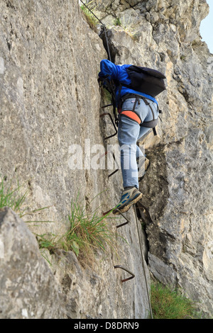 weibliche Kletterpflanze mit weißen Helm auf Sass de Rocia Klettersteig, Dolomiten Stockfoto