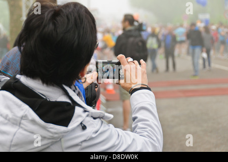Mann mit Punkt und schießen Digitalkameras fotografiert Marathonläufer – Blick durch den LCD-Bildschirm, Marathon in Heilbronn Stockfoto