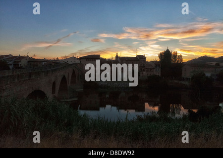 Ein Blick zurück über die Brücke in Puente la Reina (Gares) und dem Fluss Arga Spanien bei Sonnenaufgang. Stockfoto