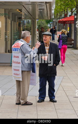 Alte christlicher Missionar, Prediger Mann, evangelisiert einen männlichen Senioren auf der Straße – Heilbronn, Deutschland Stockfoto