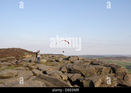 Ein Gleitschirmflieger, der über Stanage Edge im Peak District National Park Derbyshire England UK Gleitschirmfliegen sportliche Aktivität Stockfoto