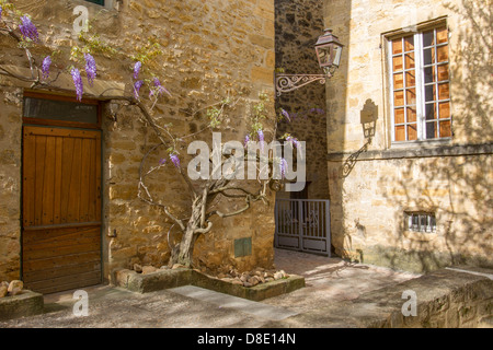 Schmiedeeisen Straßenlaterne am Nachmittag Schatten an die Wand des mittelalterlichen Steinhäusern in Hof, Sarlat, Dordogne, Frankreich Stockfoto