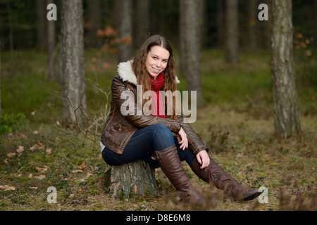 Lächelnde junge Frau im Wald Stockfoto