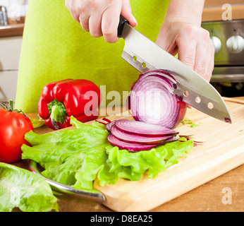 Weibes Hände schneiden Zwiebel Zwiebel, hinter frisches Gemüse. Stockfoto