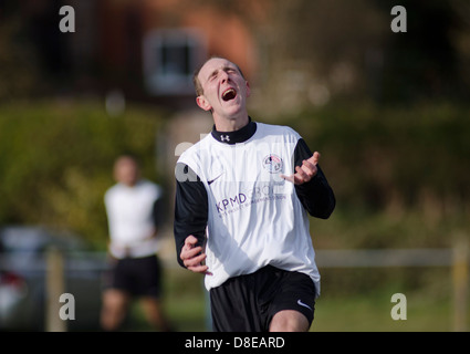Verzweiflung von einem Amateur-Fußballspieler nach einem Teamkollegen verschwendet eine Gelegenheit, ein Tor zu schießen Stockfoto