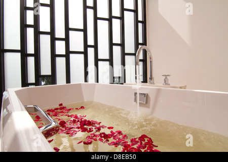 Luxus-Badewanne mit Wasser und Blumen Stockfoto
