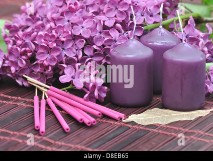 dekoriert mit Blumen lila violett, Kerzen und Weihrauch zum Entspannen Stockfoto