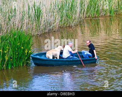 Zwei Männer und ein Hund im Ruderboot auf Fluss - Indre-et-Loire, Frankreich. Stockfoto