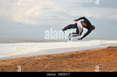 Akrobat führt am Strand Stockfoto