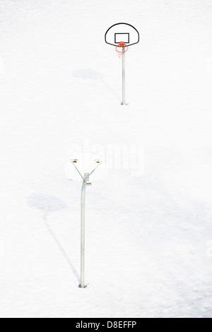 Leere Basketballfeld im Freien im Winter mit Schnee und Eis bedeckt-Feld Stockfoto