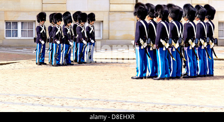 Die Wachablösung vor Amalienborg am Mittag. Amalienborg, die als eine der Residenzen der dänischen Königsfamilie, ist Tag und Nacht bewacht von Royal Life Guards. Amalienborg befindet sich in Kopenhagen, Dänemark. Es besteht aus vier Palästen um einen achteckigen Innenhof. In der Mitte des Platzes ist eine monumentale Reiterstatue Amalienborgs Gründers, König Frederick V. Stockfoto