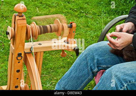 Dies ist eine Nahaufnahme der Hände auf einem Spinnrad, Alpaka Wolle spinnen. Landleben-Bild. Stockfoto