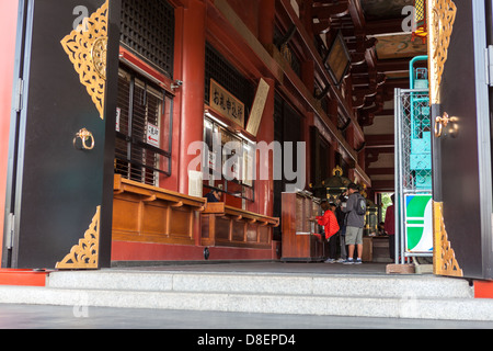 Besuchern stehen innerhalb des Main Hall Kannondo Senso-Ji Tempel und beten, Asakusa, Tokio, Japan Stockfoto