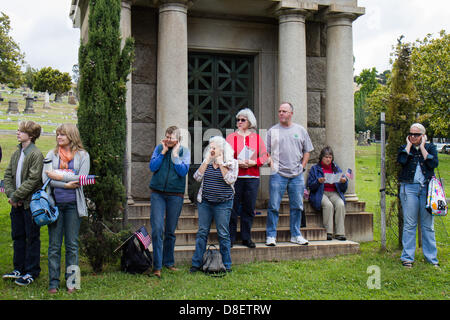 Teilnehmer, die ihre Ohren während 21 Salutschüssen auf dem 92. jährlichen Gedenktag Gedenken auf dem Mountain View Cemetery, Montag, 27. Mai 2013. Oakland, CA. Credit: John Orvis/Alamy Live-Nachrichten Stockfoto