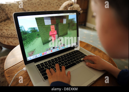 Buchen Sie 8 Jahre alter Junge auf Minecraft spielen auf einem Apple Lmac pro Laptop-computer Stockfoto