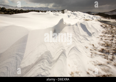 Massive Schnee driftet Block Kirkstone Pass-Straße oberhalb Ambleside im Lake District, Stockfoto