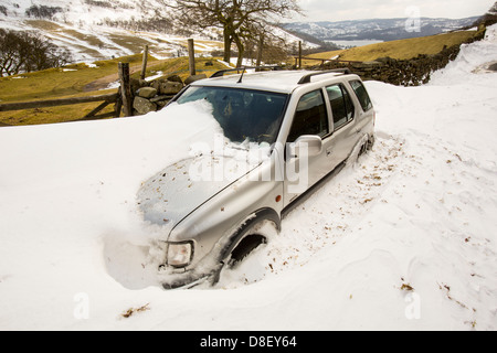 Ein vier Mal vier aufgegeben in massive Schneeverwehungen blockieren die Kirkstone Pass-Straße über Ambleside im Lake District Stockfoto