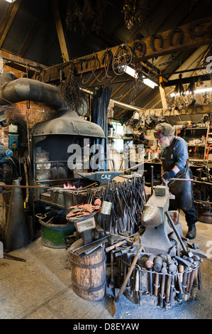 Ein Schmied Heizung Metall in der Glut des Feuers. Stockfoto