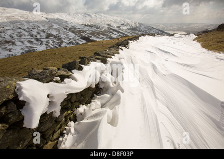 Massive Schnee driftet Block Kirkstone Pass-Straße oberhalb Ambleside im Lake District, Stockfoto