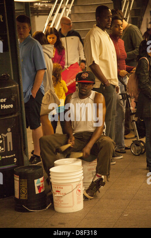 Man spielt Schlagzeug, hergestellt aus Kunststoff Dosen an der 14th Street, Union Square u-Bahn-Bahnsteig. Stockfoto