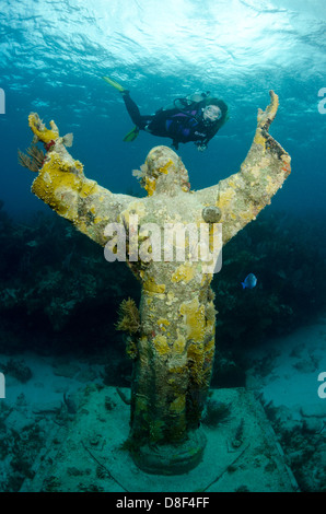 Eine weibliche Taucher schwimmt über den berühmten Christus der Abgrund Statue in Key Largo, Florida Stockfoto