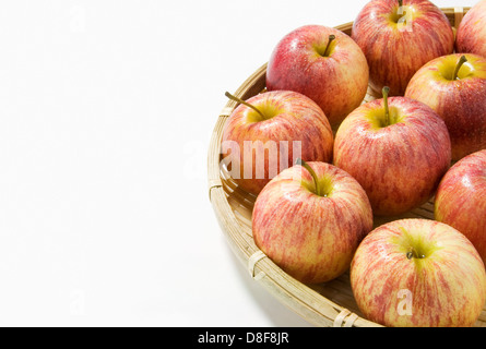 Rote Äpfel im Weidenkorb auf weißem Hintergrund Stockfoto